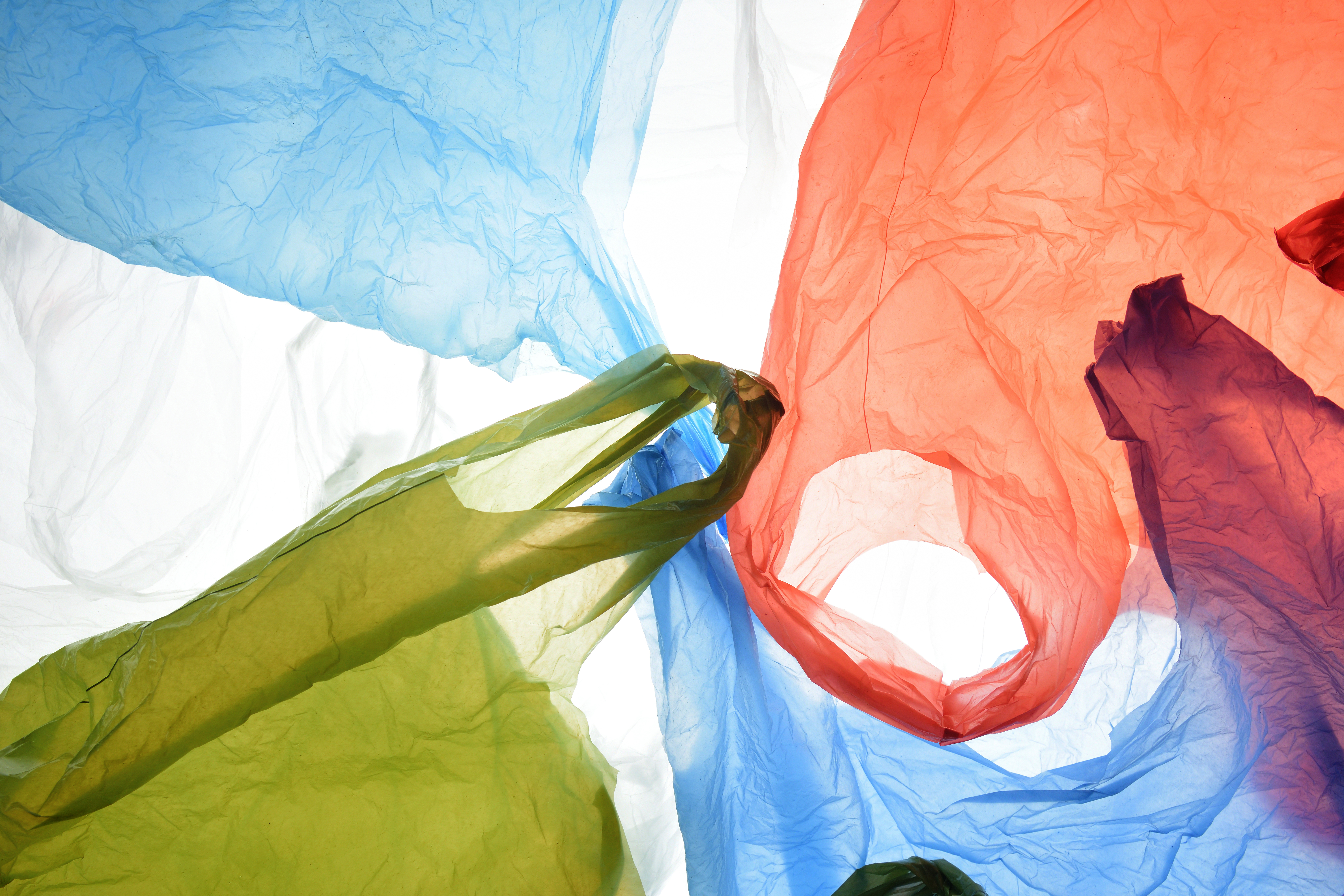 Blue, red and green single-use plastic shopping bags