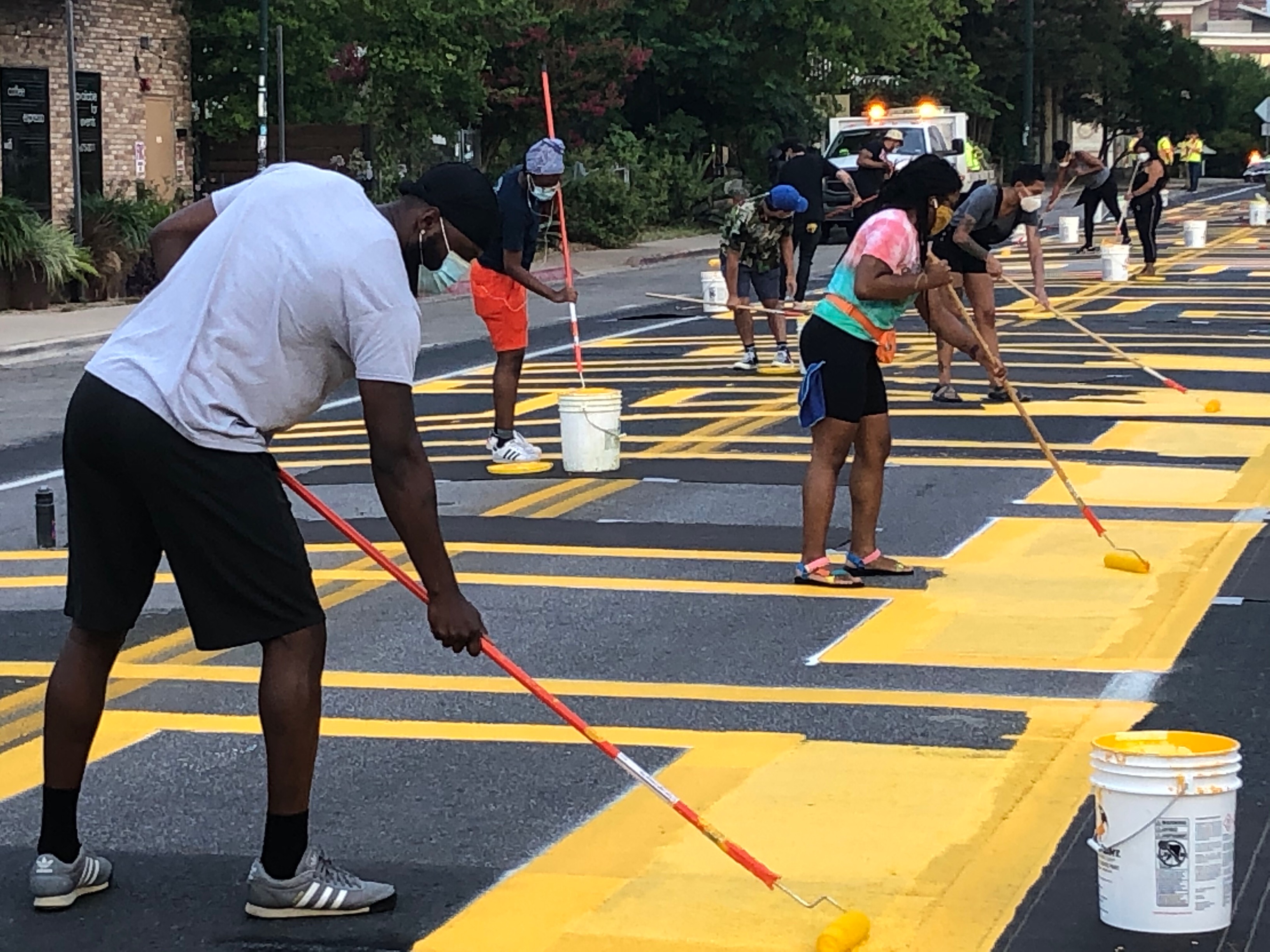 Image of artists and volunteers painting street mural