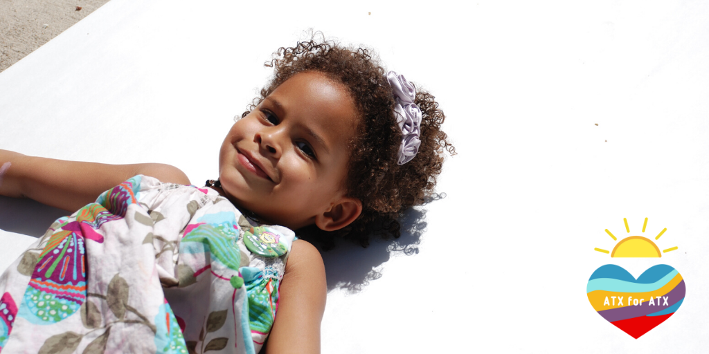 Photograph of a little girl with the ATX for ATX logo in the bottom right corner