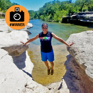 Girl balancing between two large over lake photo of girl balancing between two large rock ledges over lake