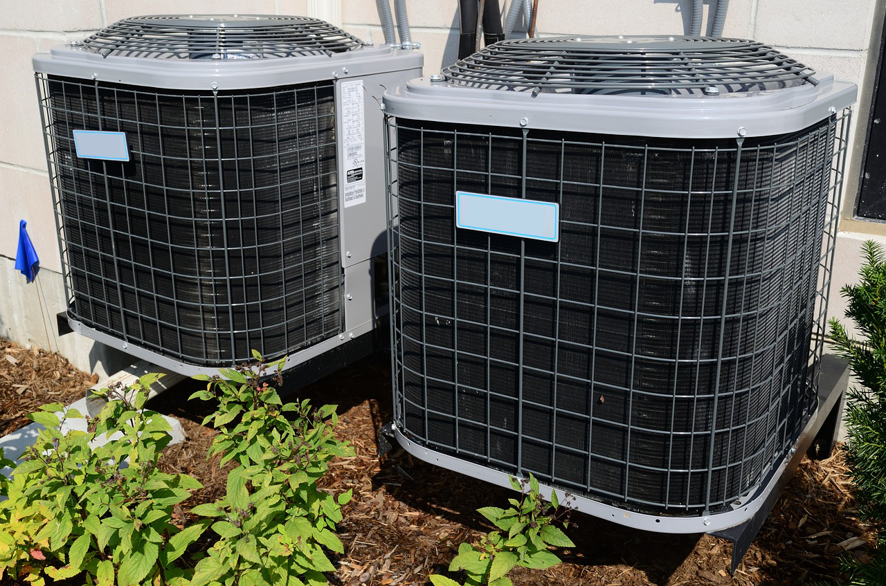 Residential Air Conditioning Units 2 black and gray metal air conditioning units near green grass and a residential unit