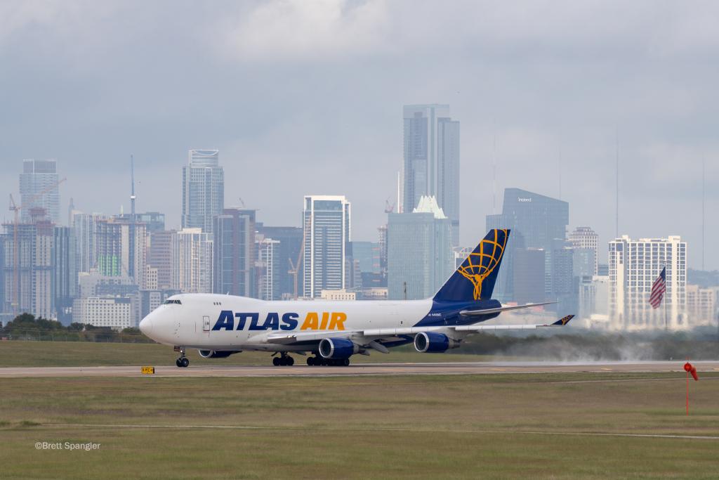 Photo of an Atlas Air boeing 747 as it lands at AUS. Downtown Austin is in the background.