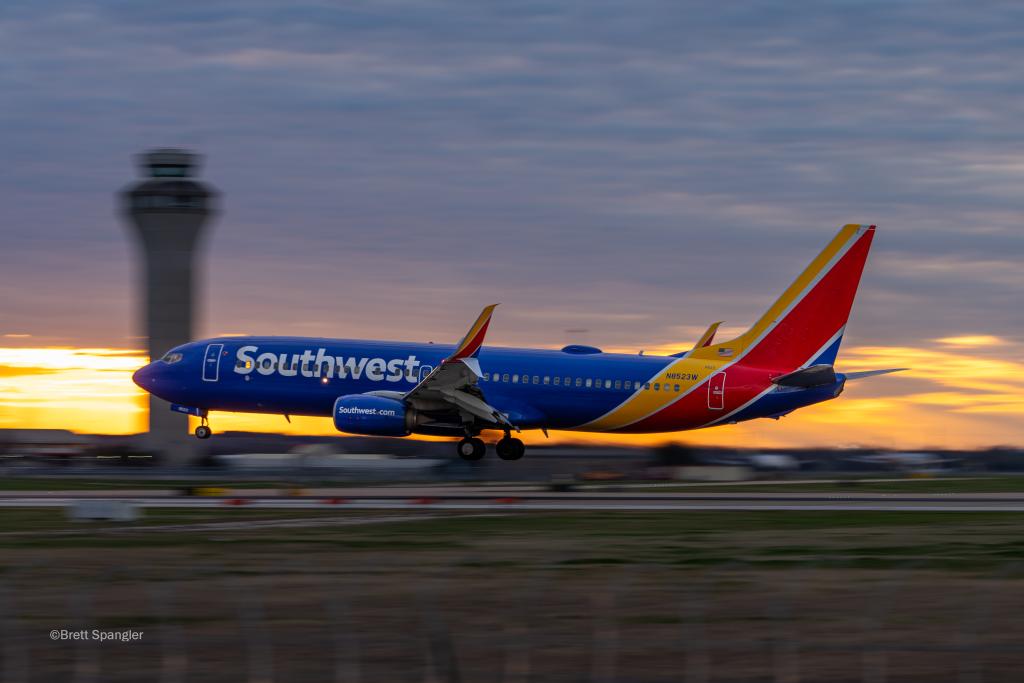 A Southwest airlines plane speeding as it departs from AUS. The plane is clear, while the background is blurred due to the speed of the aircraft.