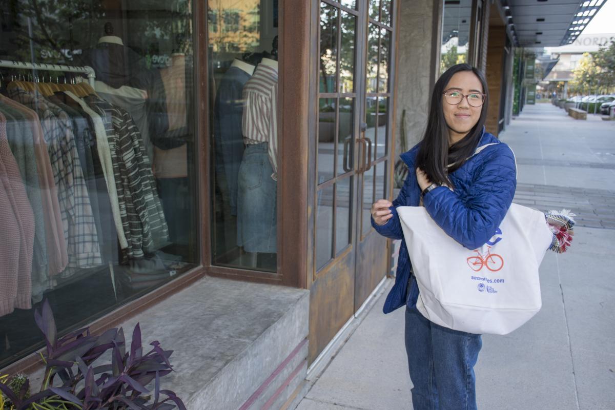 Woman shops for clothing with her reusable bag