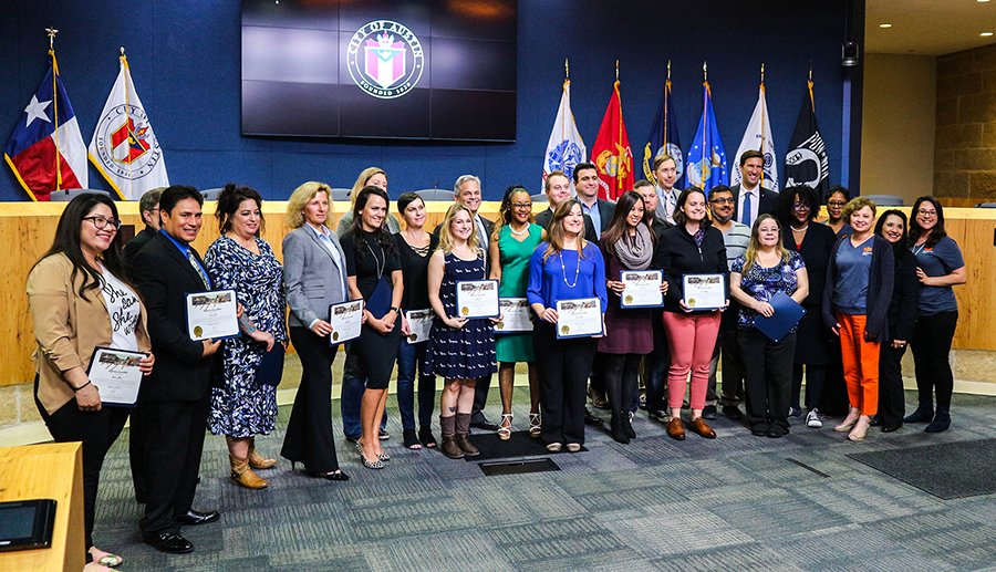 A group of graduates smiling holding their business skills certificate with Mayor Steve Adler