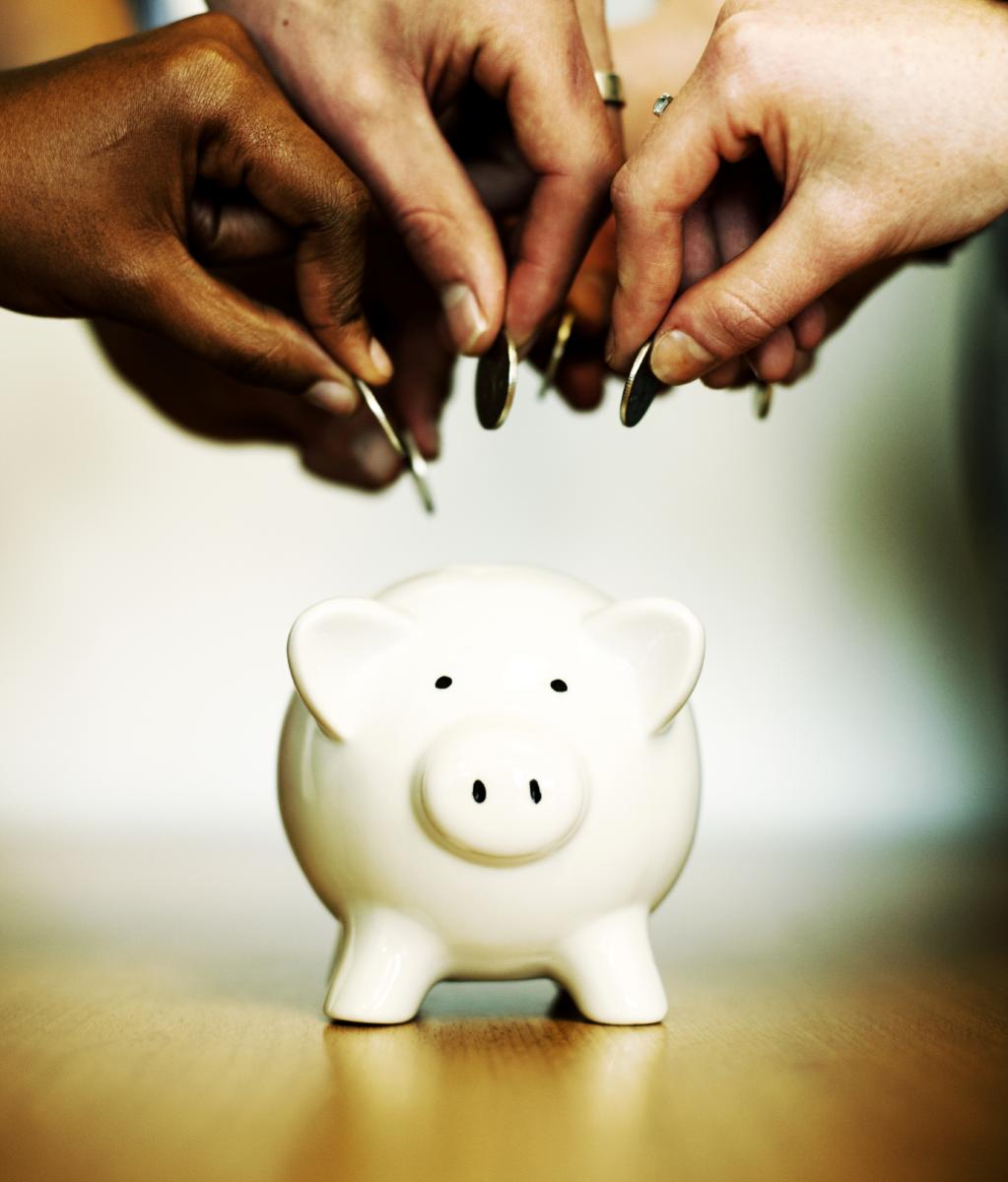 Picture of hands putting change in a piggybank