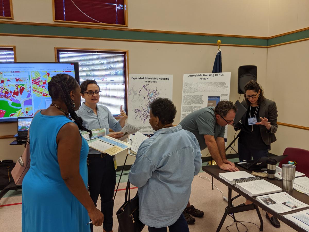 image: Austinites speak with Neighborhood Housing Staff at an Open House.