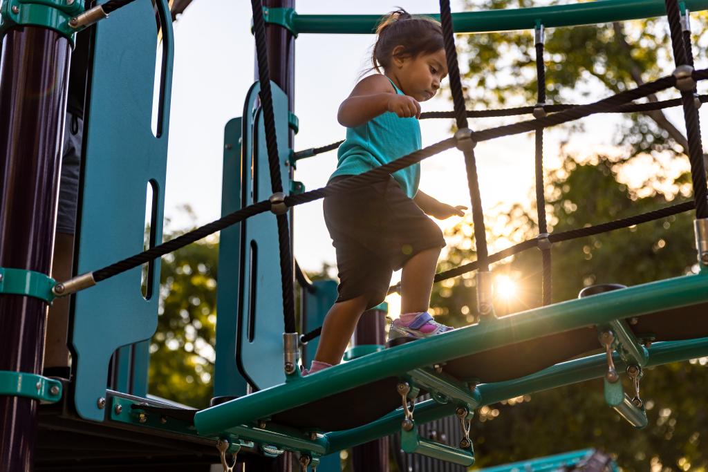 A child walks on a play structure at Govalle Neighborhood Park