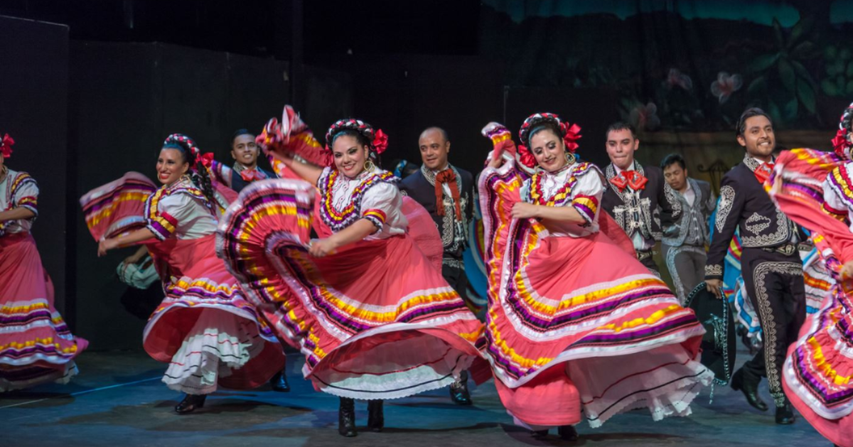 Dancers in colorful costumes dance to traditional Mexican music