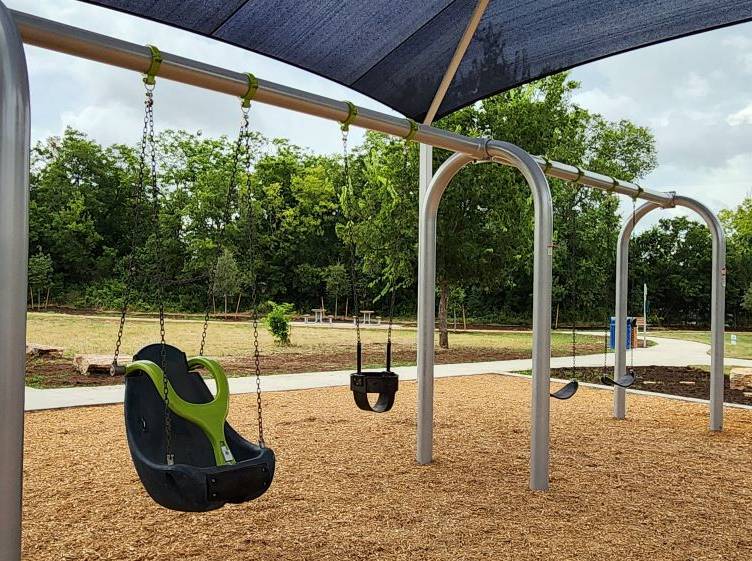 Photo of finished swing set for children aged 2-12 at Earl J. Pomerleau Pocket Park
