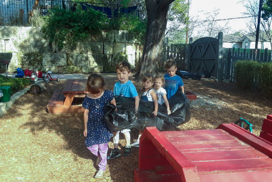 Kids carry a tarp through the schoolyard.
