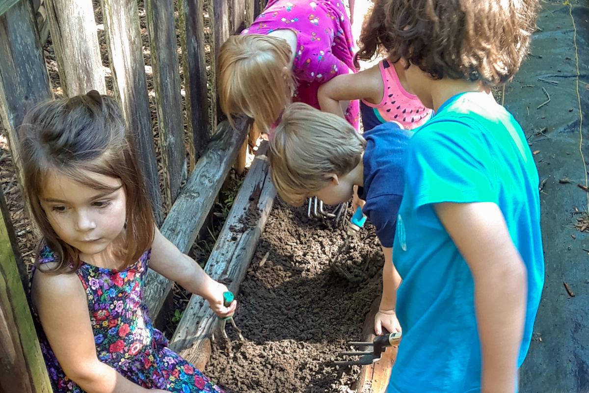 Kids are digging and planting in mini-gardens.