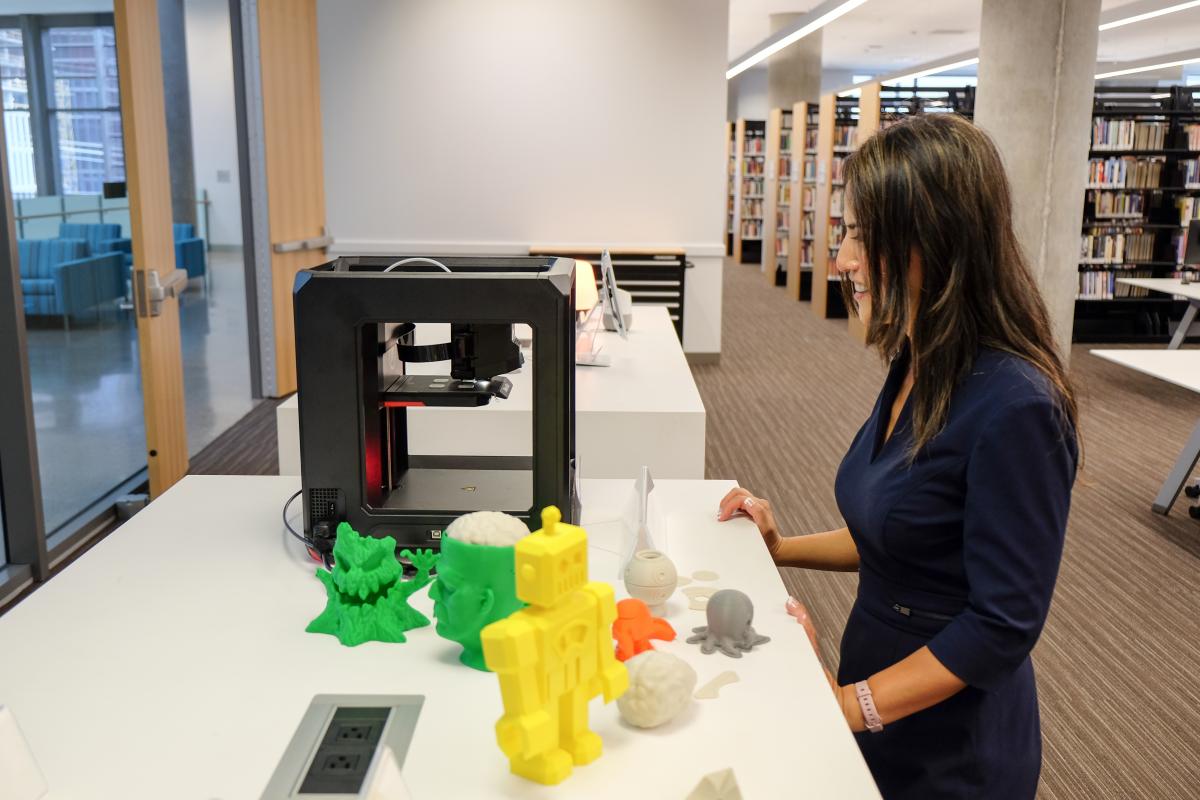 Heidi looking at the library's 3D printer and some creations that others have made.