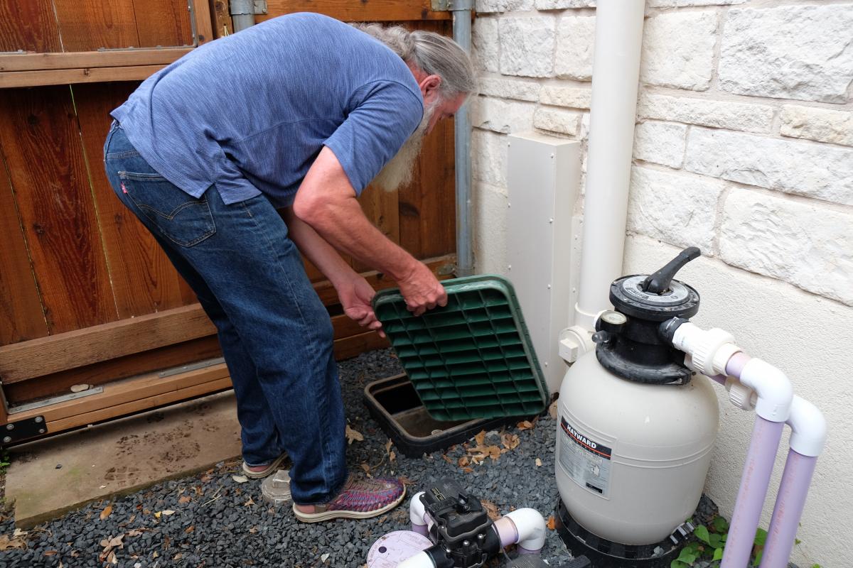 Jerry looking at the gray water system outside of the house.