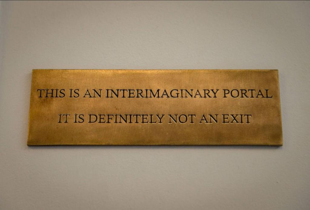 Photo of sign at Interimaginary Departures that reads: This is an interimaginary portal. it is definitely not an exit.