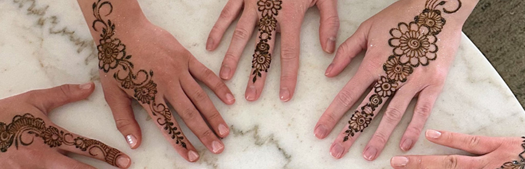 Several hands with henna designs on them