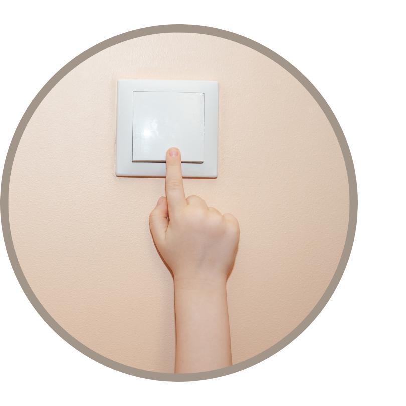 A close up of a hand reaching for a light switch.
