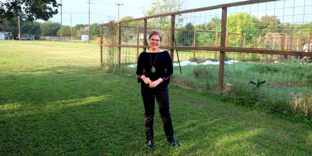 Dr. Murillo stands in front of El Buen's community garden space.