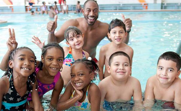 Happy children in pool Group of happy children in pool standing with adult