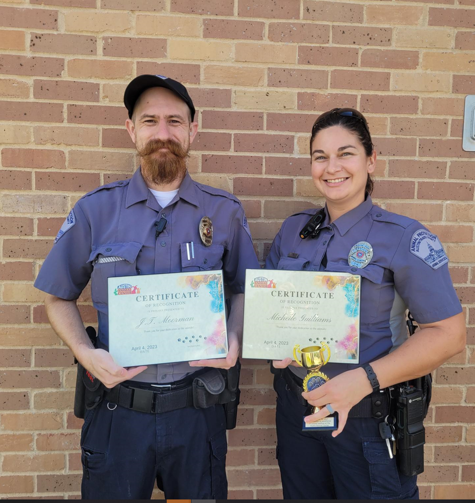 Two animal protection officers holding certificates