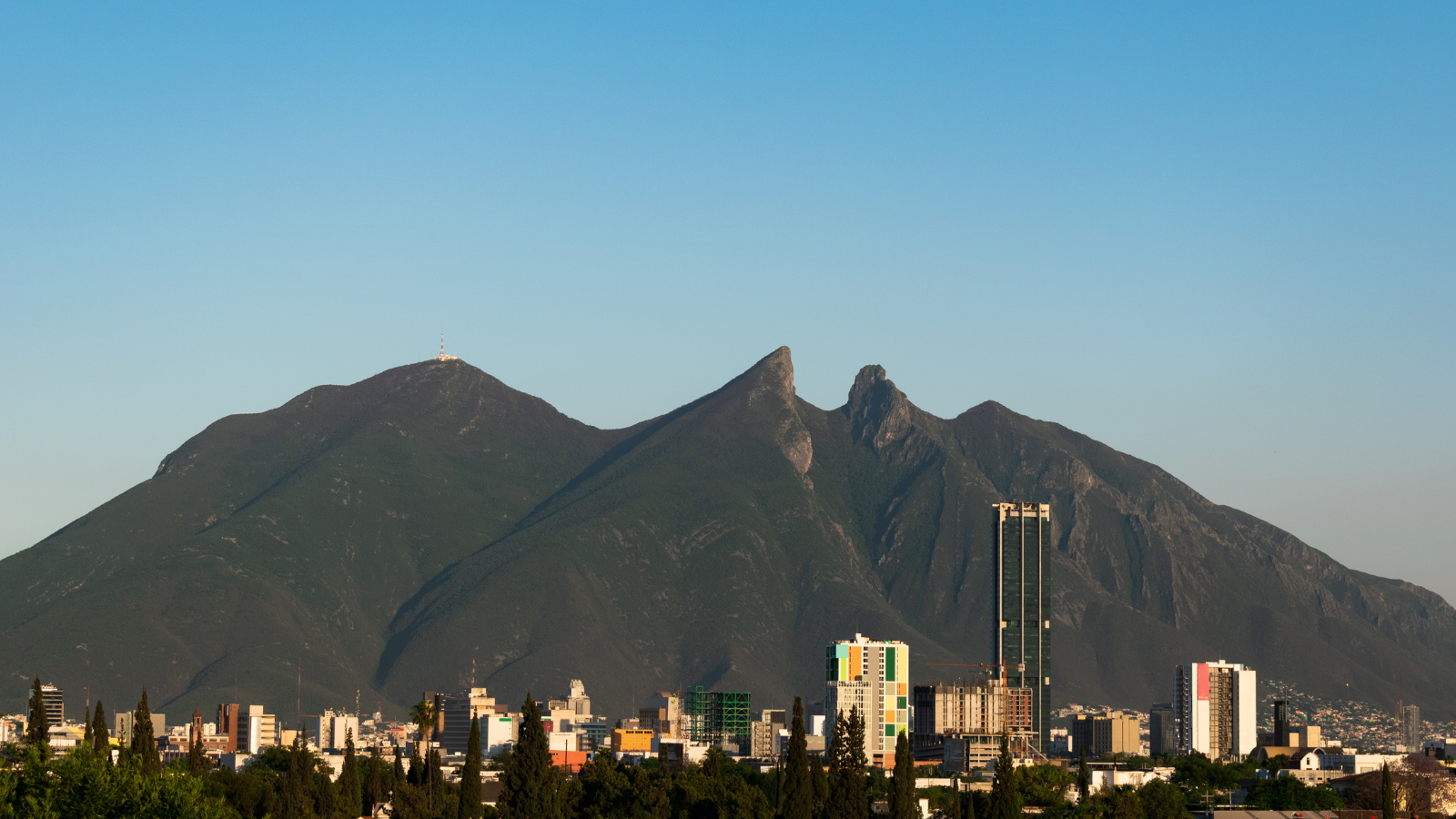 Mountain range in the background. Downtown city with buildings.
