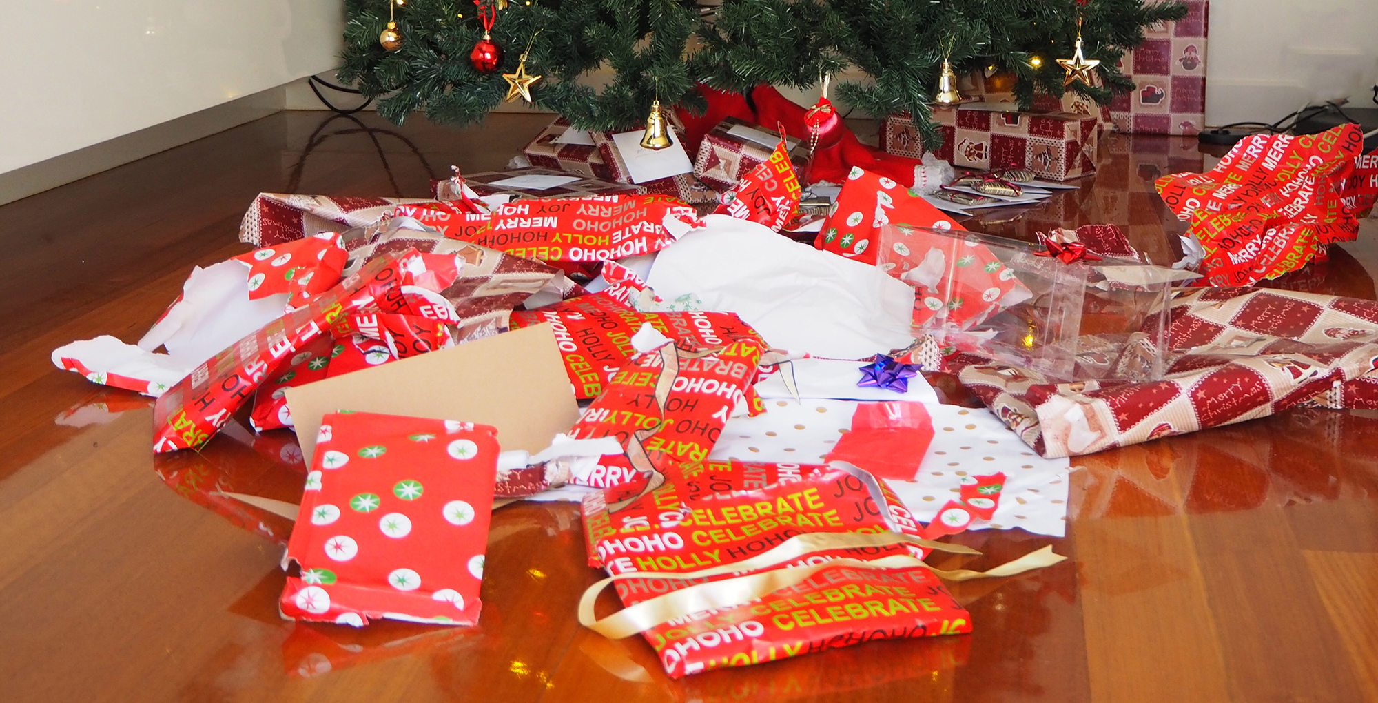 Piles of torn open wrapping paper on the floor.