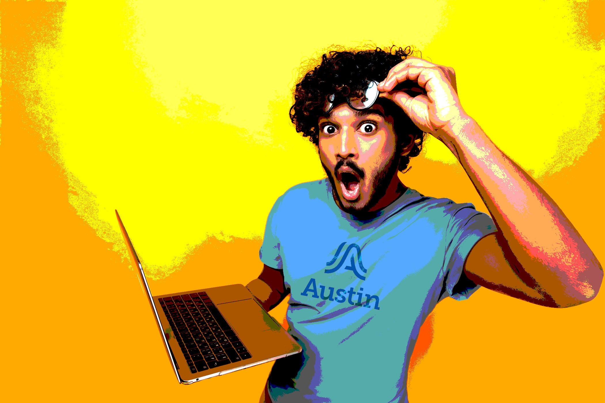 Man raising glasses in excitement looking at laptop