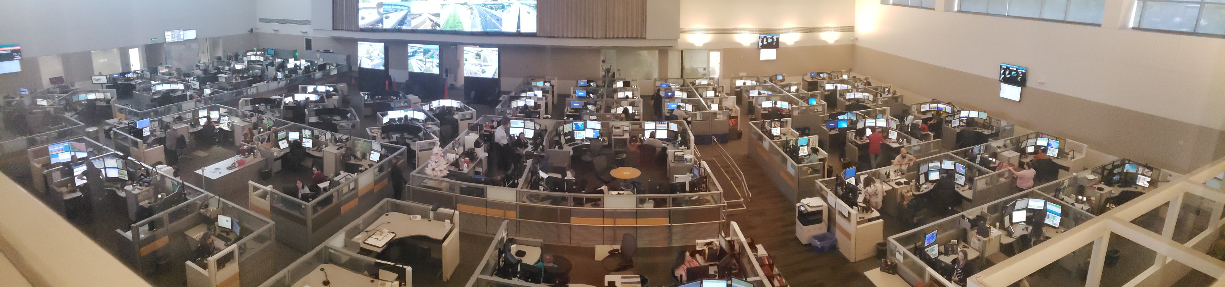 Emergency Call Center staff working in front of multiple TV monitors