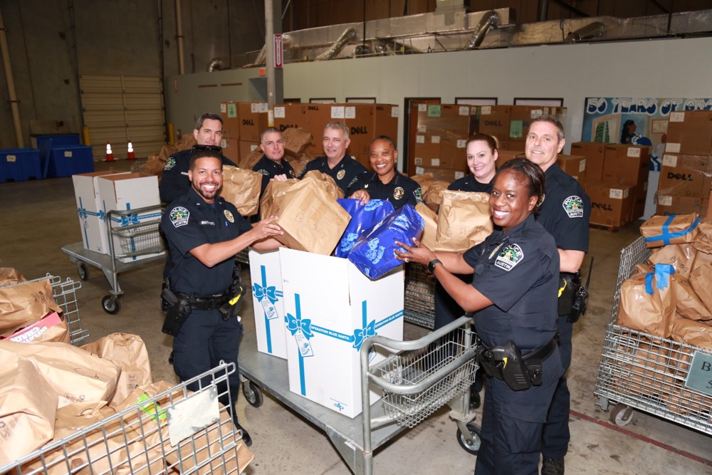 APD Officers prepare gifts for Operation Blue Santa to help local families.