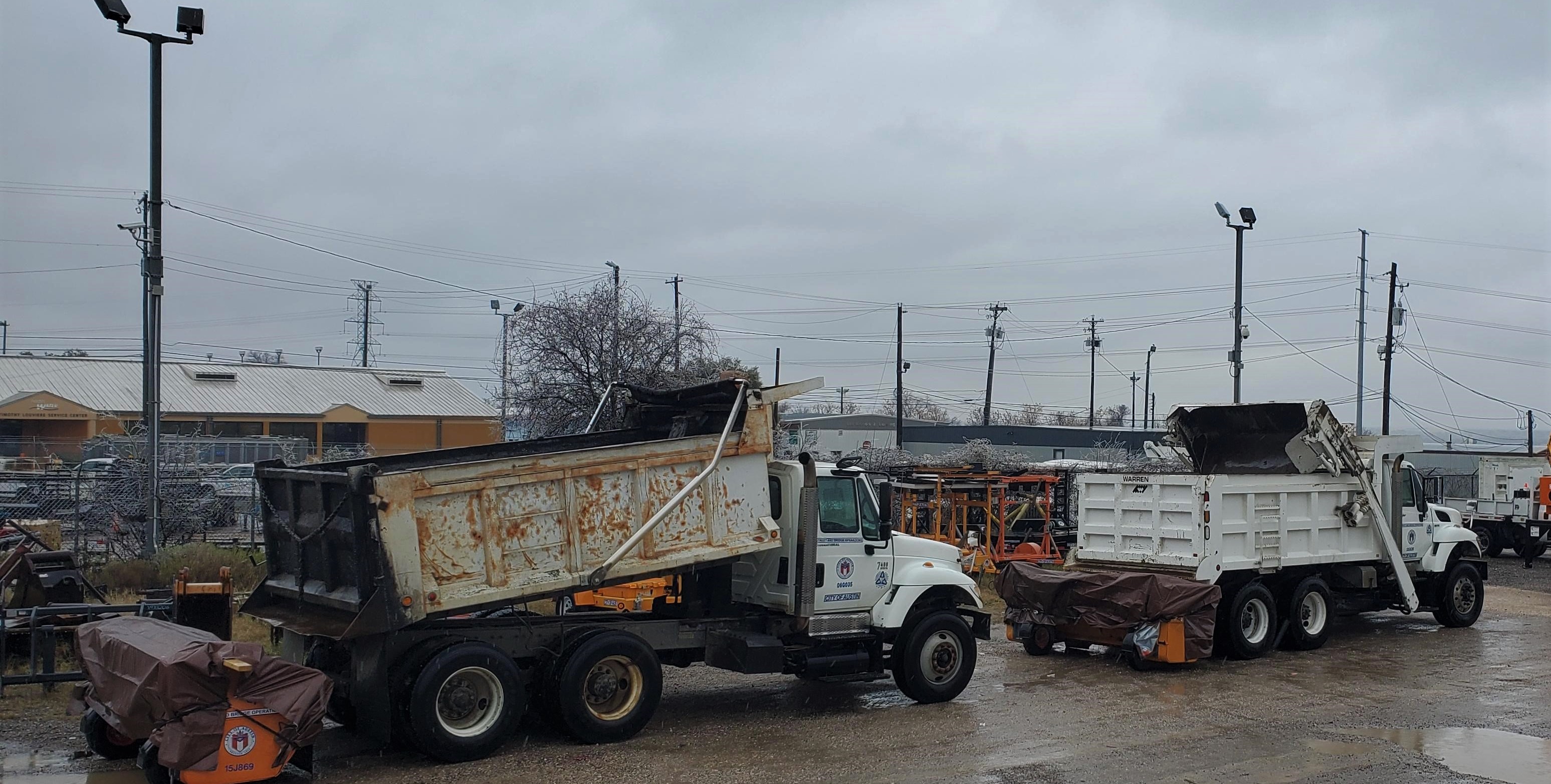 Public Works dump trucks with dolomite spreaders attached ready to go. Three Public Works dump trucks with dolomite spreaders lined up ready to respond.