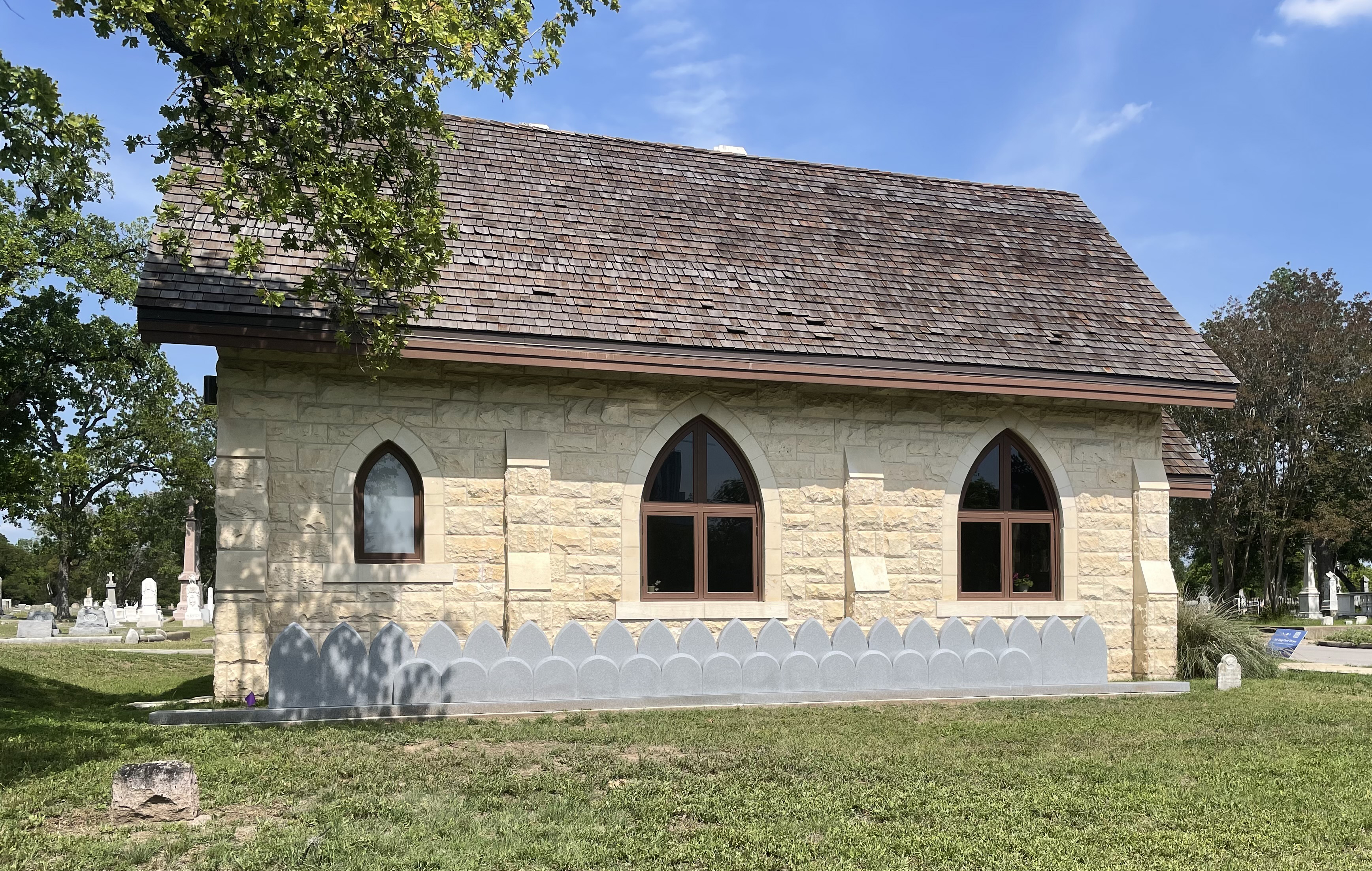 Brick cemetery building at Oakwood Cemetery with memorial tombstones