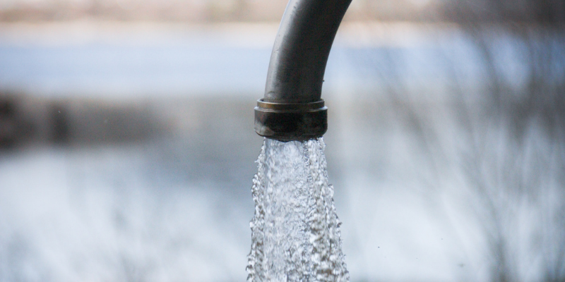 Image of water flowing from a faucet with blurred background