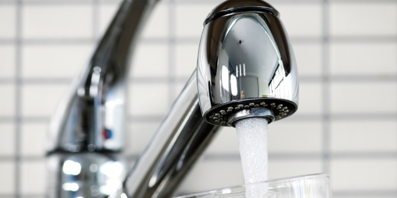 Boil Water Notice Lifted for Some Austin Water Wholesale Customers Image of a kitchen water faucet with water flowing out of it