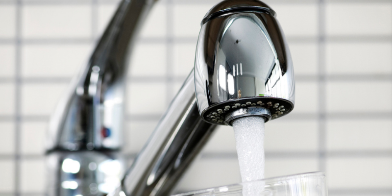 Image of a kitchen water faucet with water flowing out of it