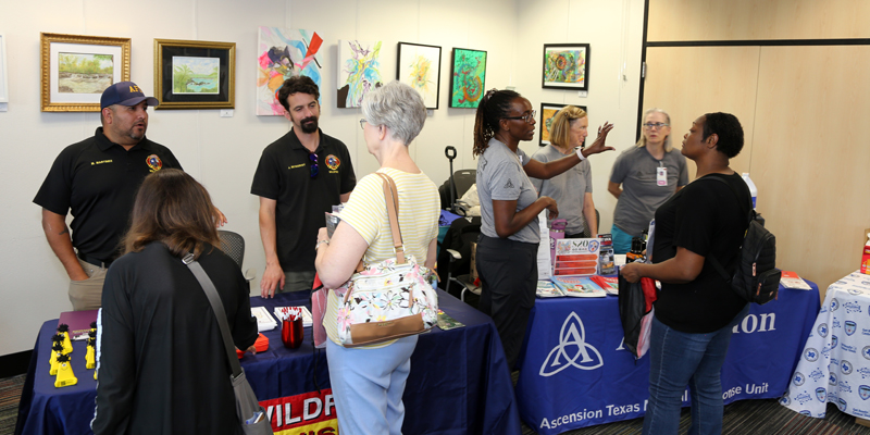 A photo showing community members visiting educational booths at an Emergency Preparedness Pop-up in a library.