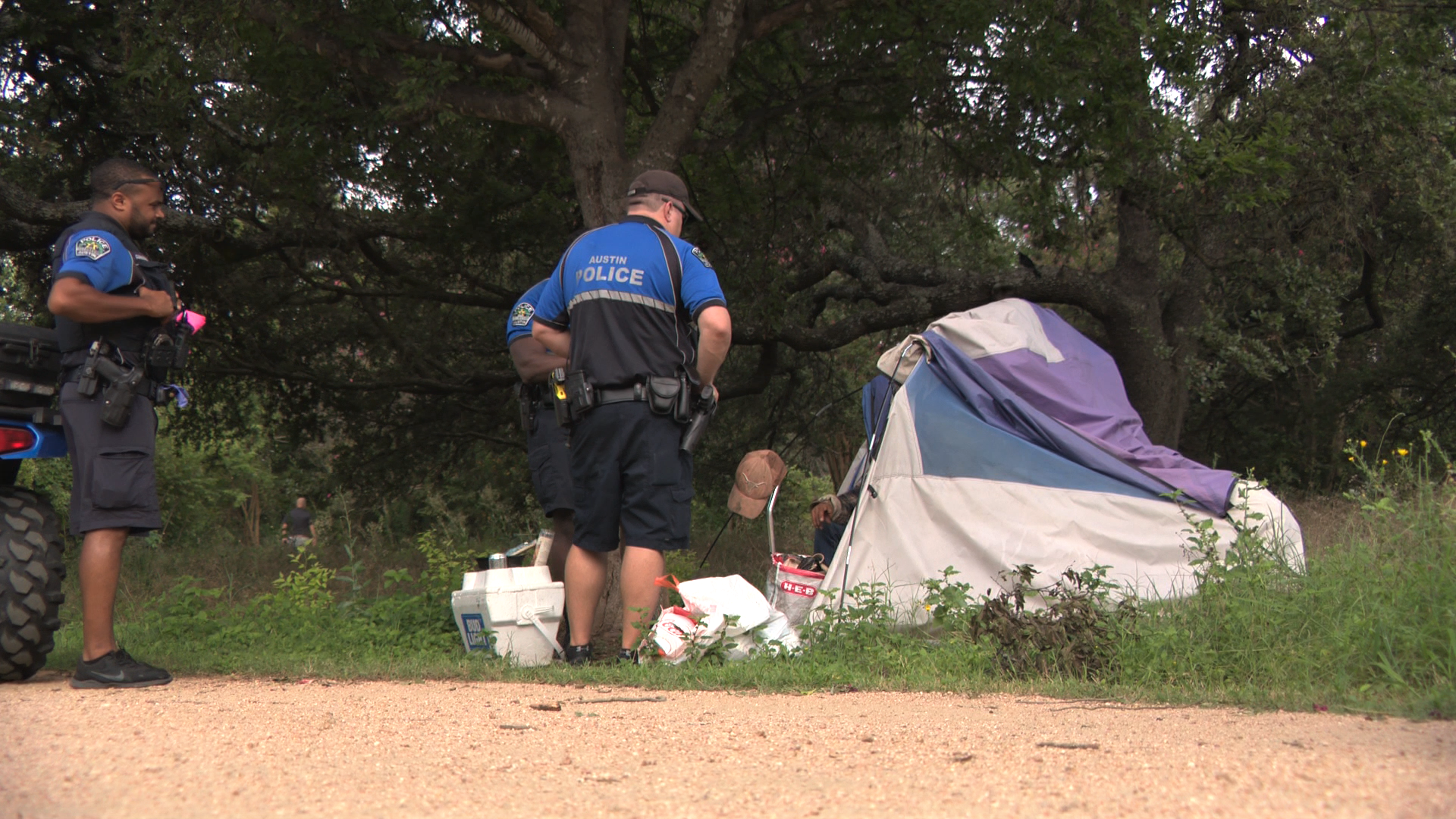 Photo of APD officers speaking with a person experiencing homelessness