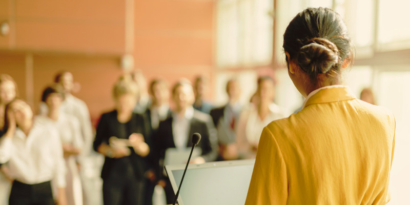 a woman presenting to a room in a professional setting