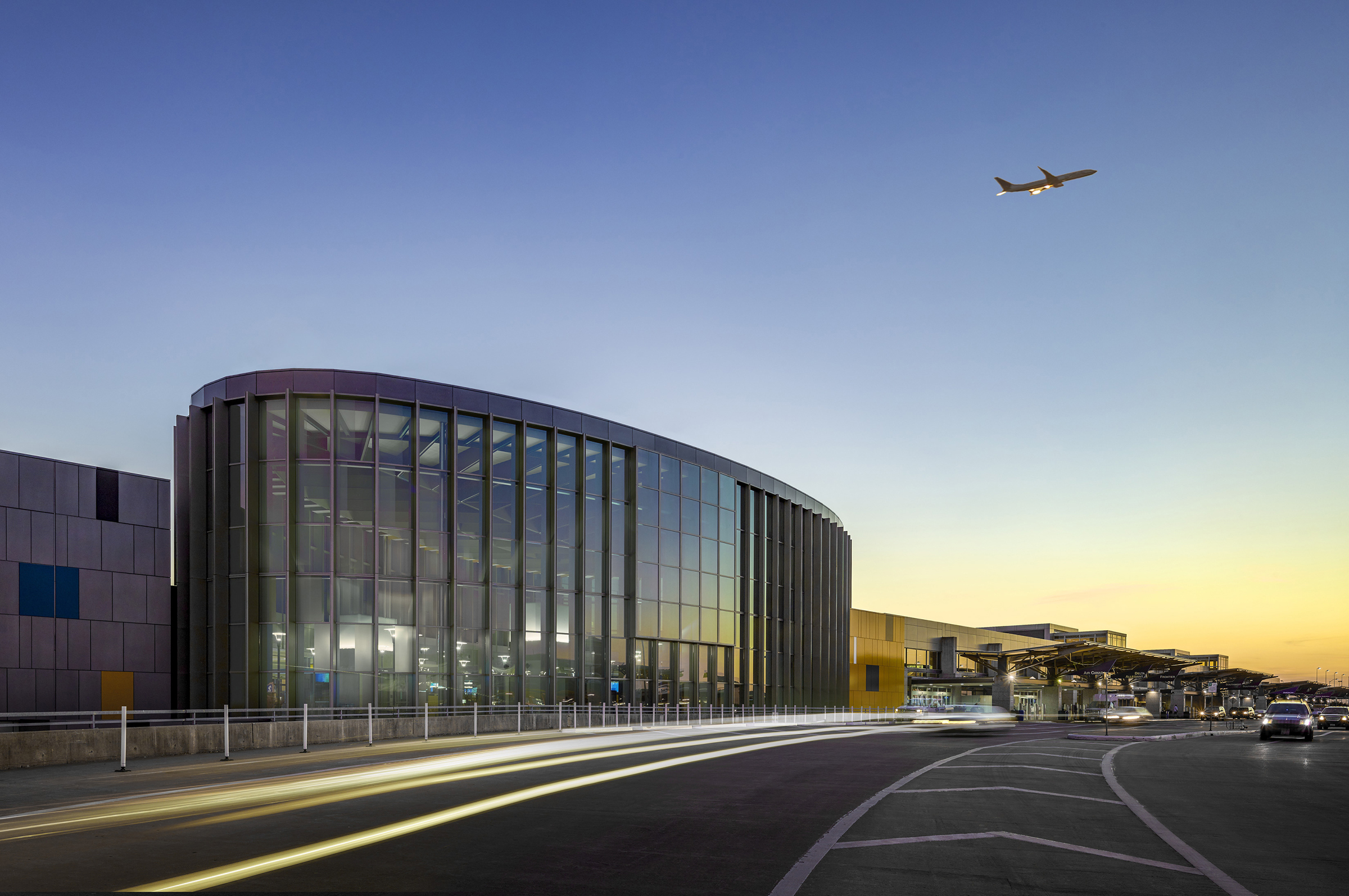 A plane flies above the Barbara Jordan Terminal