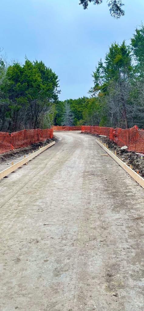Trail bed prepared for concrete installation along urban trail network.