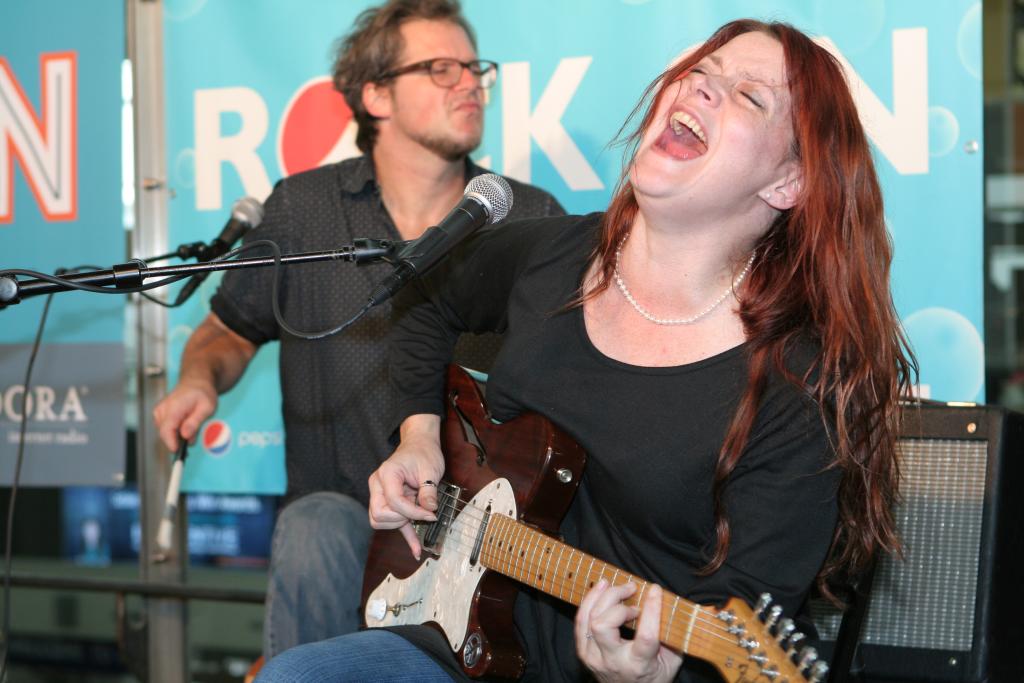 Carolyn Wonderland singing and playing guitar, her eyes closed