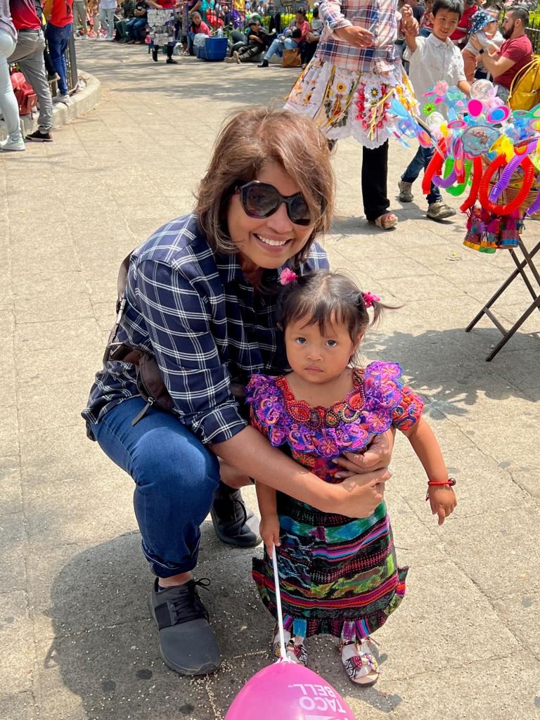 Woman standing with little girl in native Guatemalan dress.