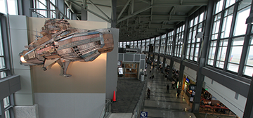 A large 2-D, blimp-like ship mounted above the concourse in the terminal