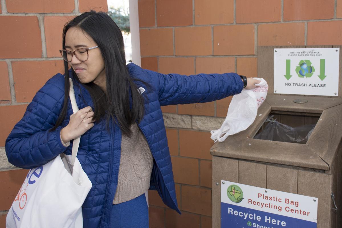 Woman recycles plastic bag with disgusted look on her face