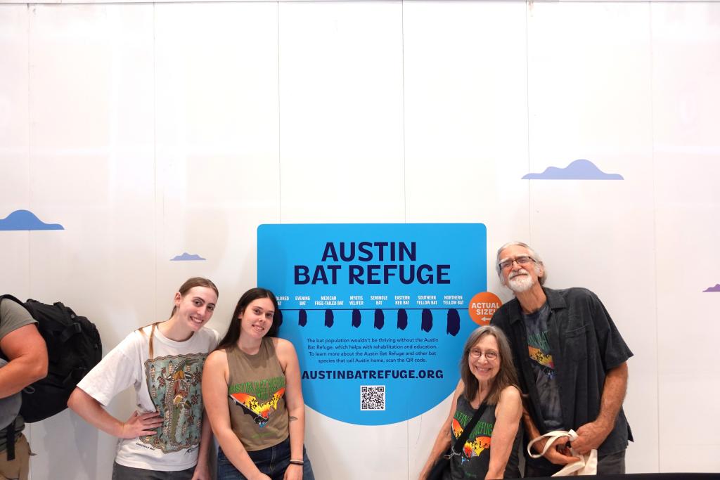 Austin Bat Refuge staff and volunteers in front of the bat wall at AUS