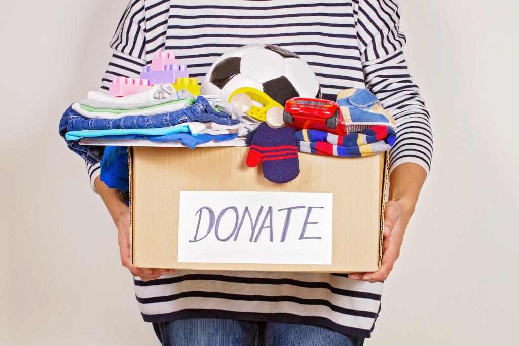 Person holds a box of items to donate