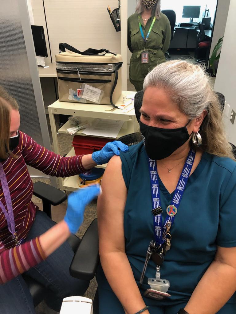 Photo: Senior Registered Nurse (RN) Nelda Garcia receives the first COVID-19 vaccine administered by Austin Public Health.