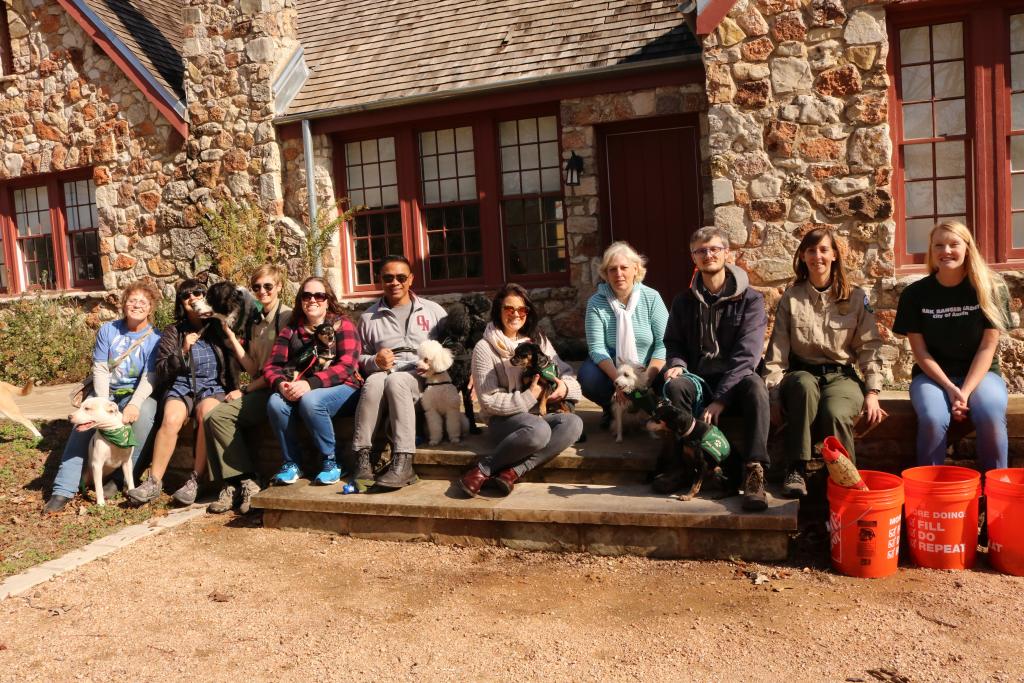 images of 12 people with dogs sitting in front of stone cottage