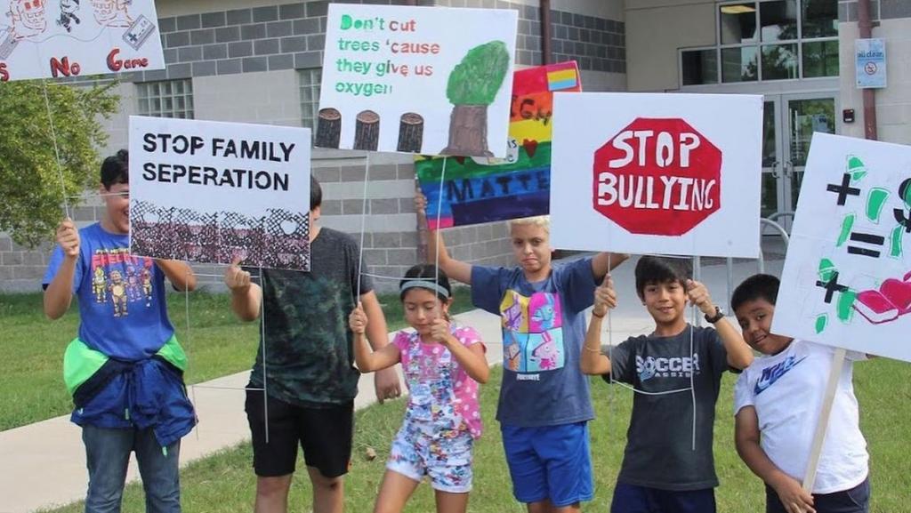 kids holding signs with advocacy messages