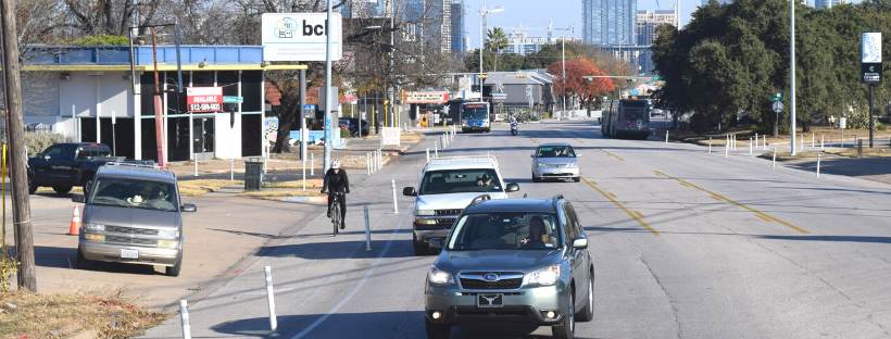 photo of a person biking on a busy street