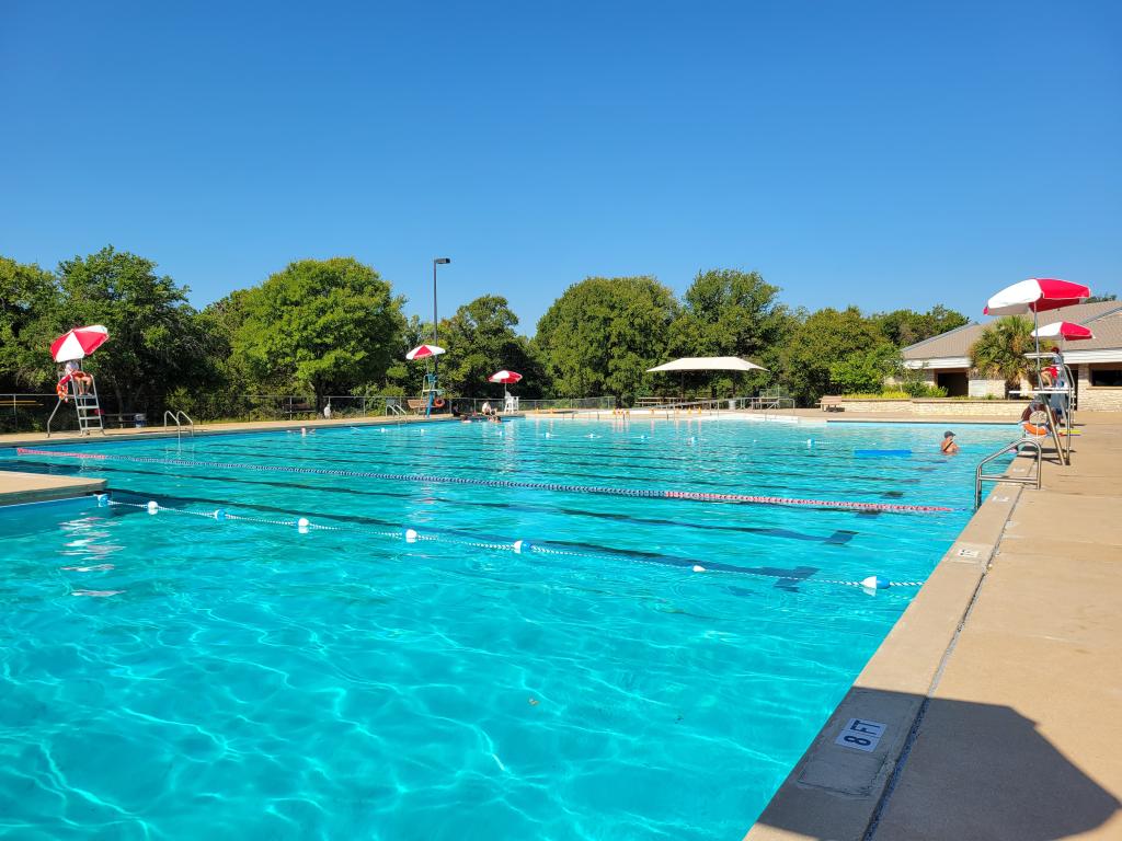 Photo of walnut creek pool, lap lanes, guard stands and trees.